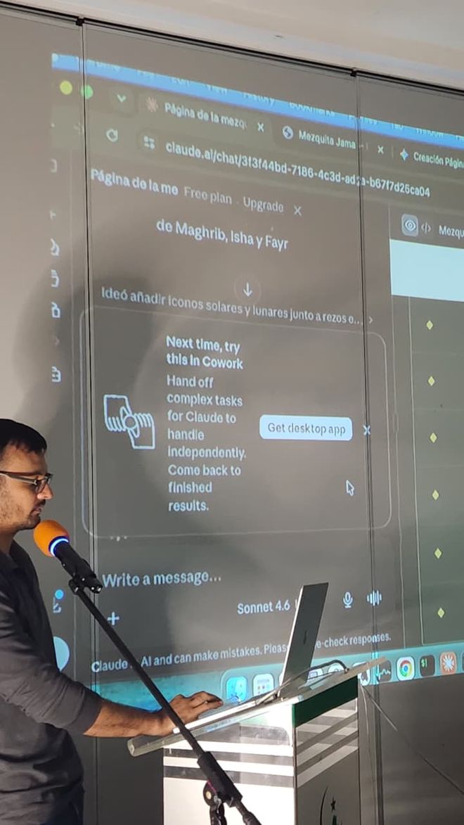 Arsalan at a podium building a website live, with Claude projected on the screen behind him.